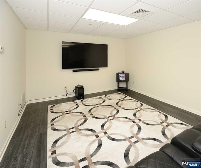 interior space featuring dark wood-type flooring and a drop ceiling