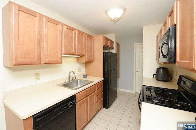 kitchen with light tile patterned flooring, sink, light brown cabinets, and black appliances