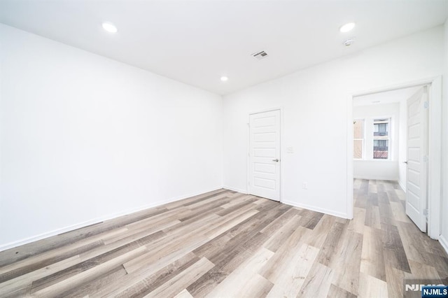 empty room with recessed lighting, baseboards, and wood finished floors