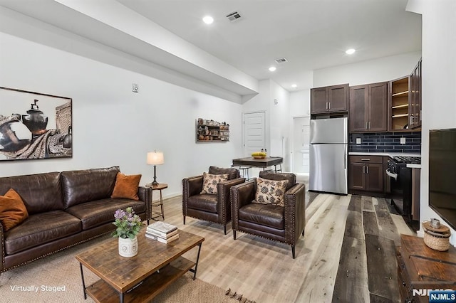 living room featuring recessed lighting, visible vents, and light wood-type flooring