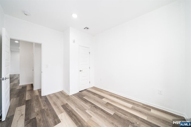 unfurnished bedroom featuring visible vents, recessed lighting, baseboards, and wood finished floors