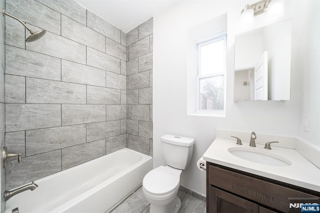 full bathroom featuring baseboards, toilet, vanity, and shower / tub combination