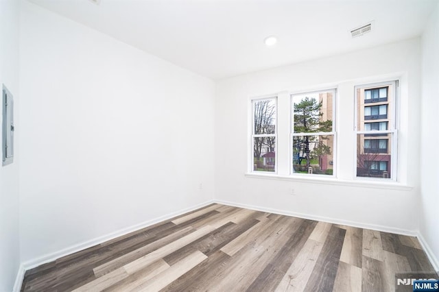 spare room featuring recessed lighting, visible vents, baseboards, and wood finished floors