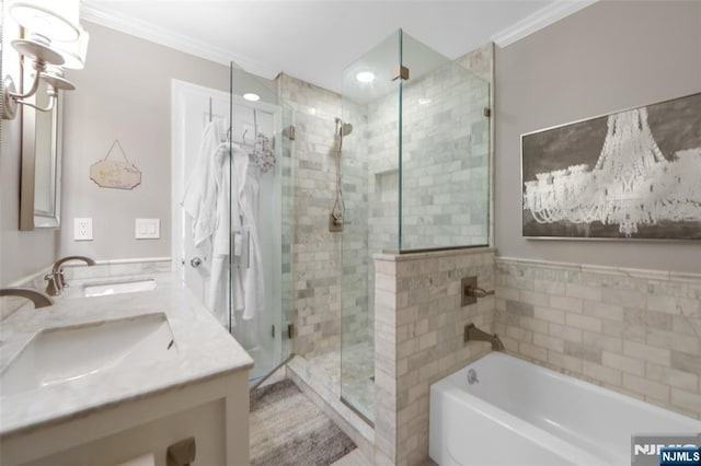 bathroom featuring ornamental molding, shower with separate bathtub, and vanity