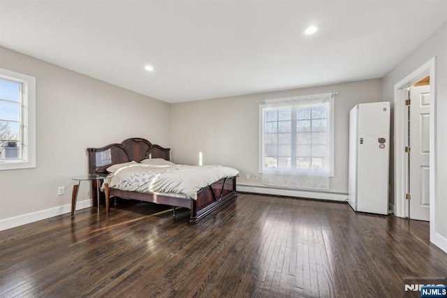 bedroom with baseboard heating and dark hardwood / wood-style floors