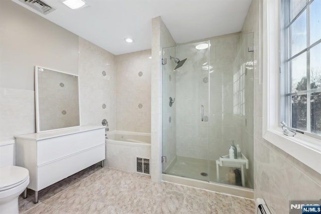 bathroom with independent shower and bath, toilet, and baseboard heating