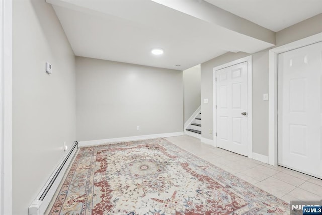 basement featuring light tile patterned floors and a baseboard radiator