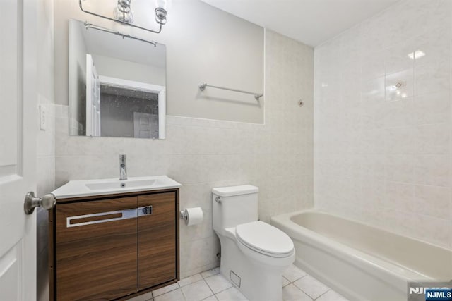 full bathroom with tile patterned floors, toilet, tile walls, vanity, and shower / bath combination