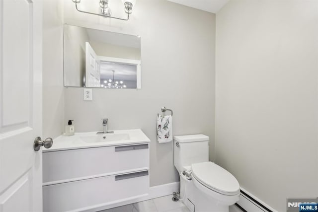 bathroom featuring vanity, a baseboard heating unit, and toilet