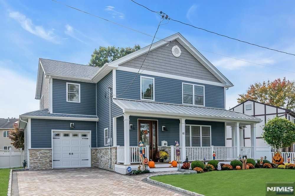 view of front facade with a garage, a front yard, and a porch