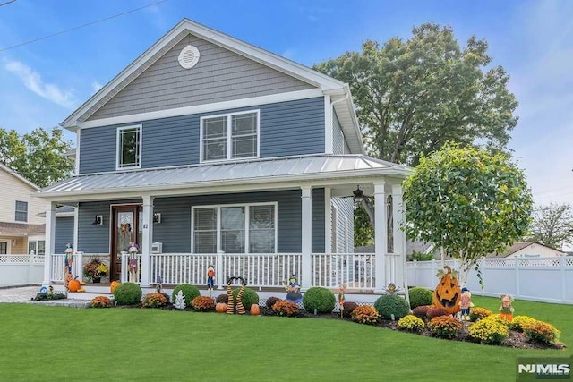 farmhouse-style home featuring covered porch and a front yard