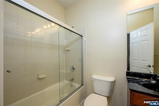 full bathroom with vanity, enclosed tub / shower combo, and toilet