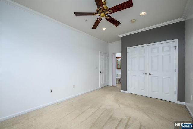 unfurnished bedroom with crown molding, connected bathroom, light colored carpet, and ceiling fan