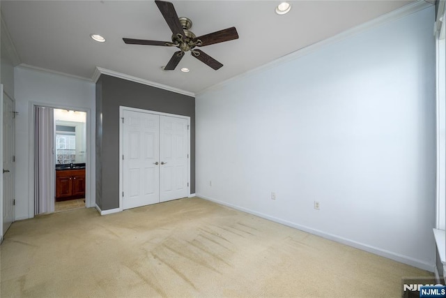 unfurnished bedroom with connected bathroom, light carpet, ornamental molding, a closet, and ceiling fan