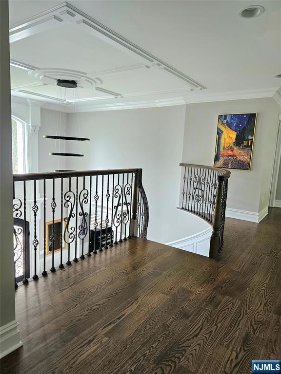 corridor featuring ornamental molding, wood finished floors, an upstairs landing, and baseboards