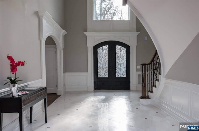 foyer entrance featuring decorative columns and french doors