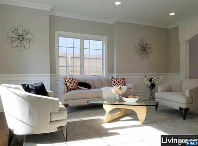 living area with recessed lighting, a wainscoted wall, and crown molding