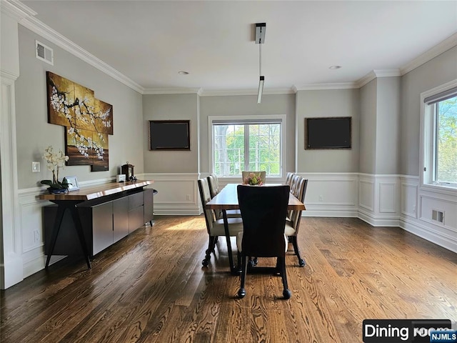 dining space with wainscoting, wood finished floors, and visible vents