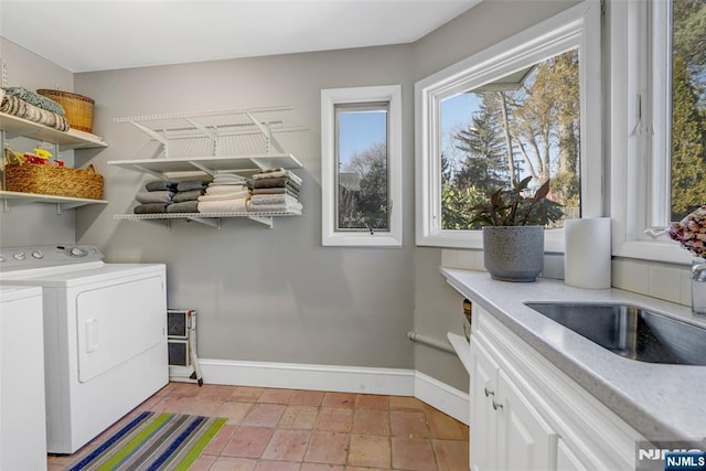 laundry room with light tile patterned flooring, cabinets, sink, and washing machine and dryer