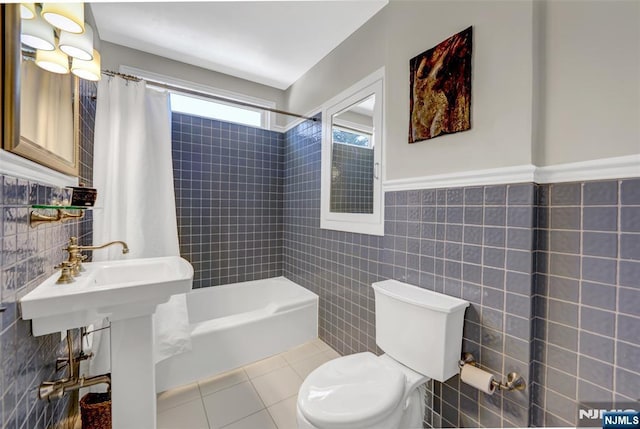 bathroom with tile walls, tile patterned floors, toilet, and shower / bathtub combination with curtain