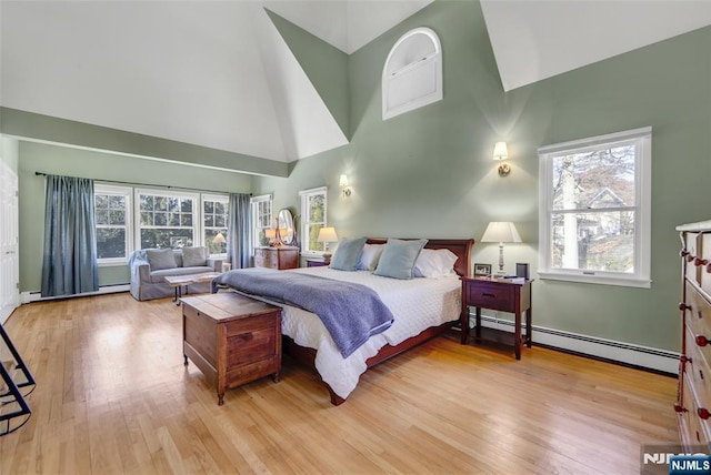 bedroom with light hardwood / wood-style flooring, high vaulted ceiling, and baseboard heating