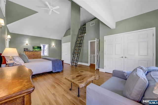 bedroom with hardwood / wood-style flooring, high vaulted ceiling, ceiling fan, and a closet