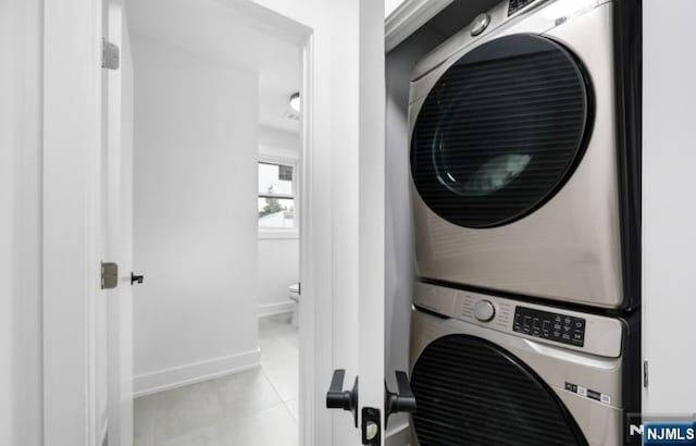 23 Roma St, Nutley, NJ 07110 - clothes washing area with light tile patterned floors, baseboards, laundry area, and stacked washer and clothes dryer