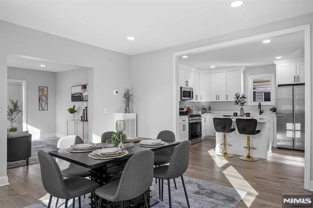 dining room with dark hardwood / wood-style floors and sink