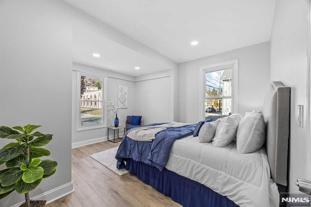 bedroom featuring multiple windows and light hardwood / wood-style flooring