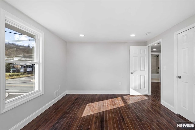 unfurnished room with dark wood-type flooring