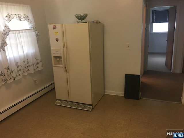 kitchen with white refrigerator with ice dispenser and a baseboard heating unit