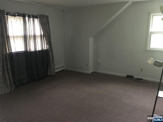 additional living space with vaulted ceiling, carpet floors, and baseboard heating