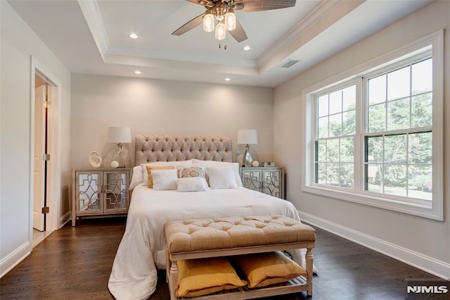 bedroom with dark hardwood / wood-style flooring, a tray ceiling, ornamental molding, and ceiling fan