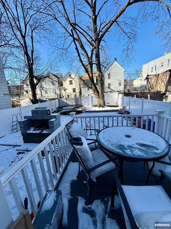 snow covered patio featuring a deck