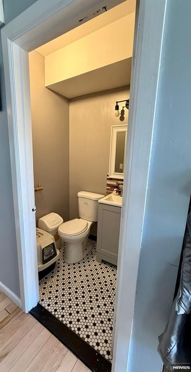 bathroom featuring vanity, toilet, and hardwood / wood-style floors