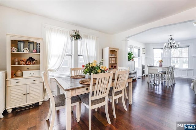 dining room with dark wood-type flooring, radiator heating unit, and a chandelier