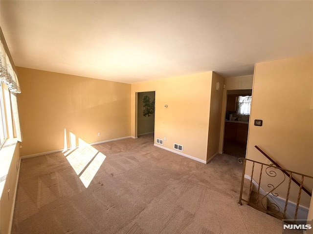 spare room featuring light colored carpet