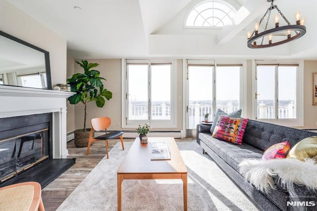 living room featuring wood-type flooring, a wealth of natural light, and a chandelier