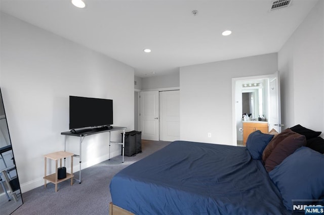 carpeted bedroom featuring ensuite bath and a closet