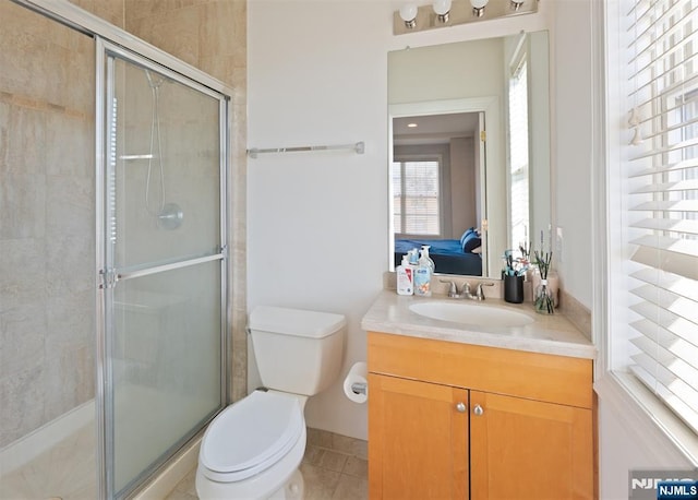 bathroom with vanity, tile patterned floors, toilet, and walk in shower