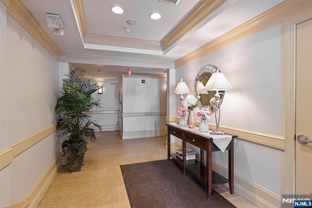 corridor with a tray ceiling and crown molding