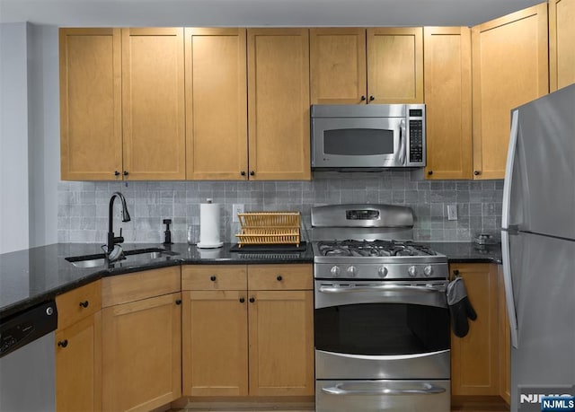 kitchen featuring dark stone countertops, sink, tasteful backsplash, and stainless steel appliances