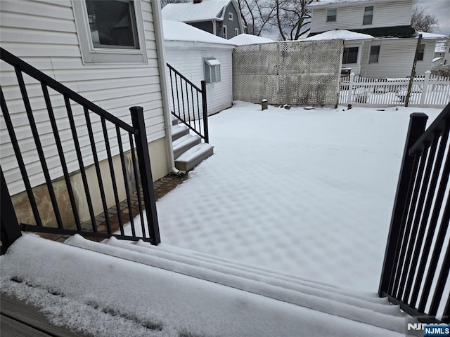 yard layered in snow with fence