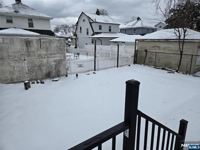 yard layered in snow featuring fence and a residential view