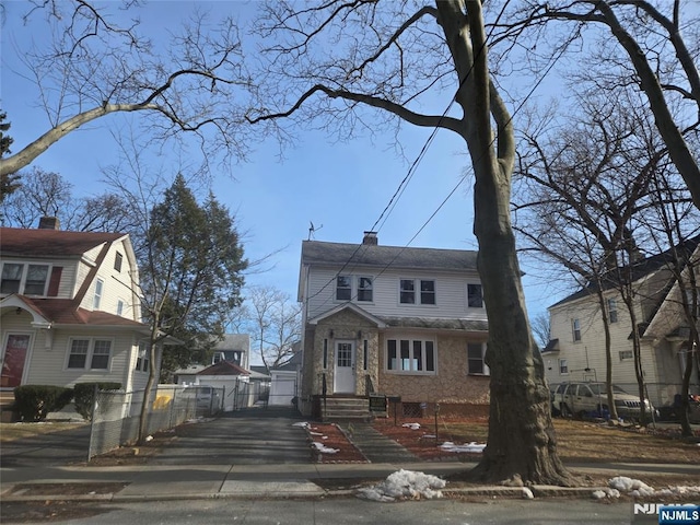 view of front of house featuring a chimney and fence