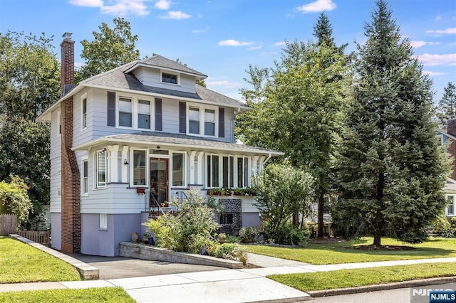 front of property with covered porch and a front lawn