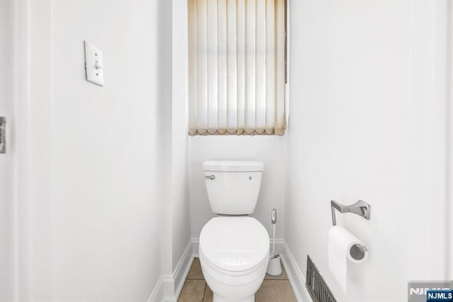 bathroom with toilet and tile patterned flooring