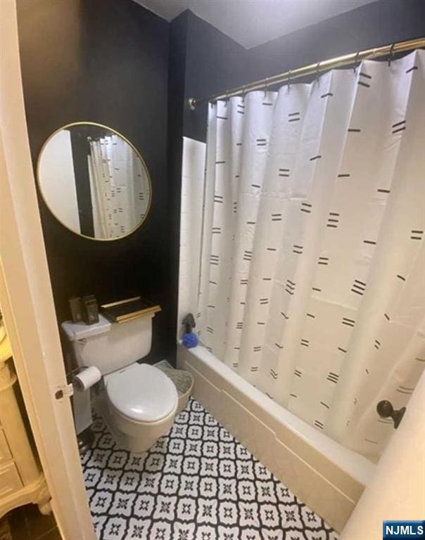 bathroom featuring shower / tub combo with curtain and toilet