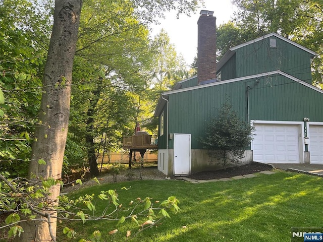 view of side of home with a chimney, a yard, and a deck