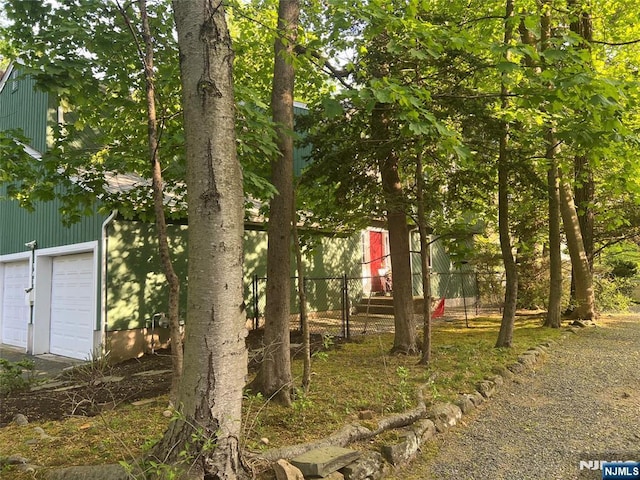 view of yard featuring fence and a garage